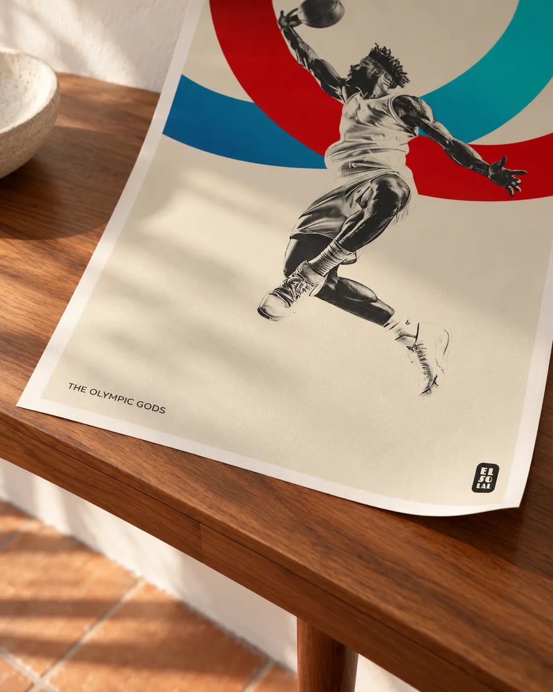 A corner of The Basketball lifting, the grain of the paper in raking light