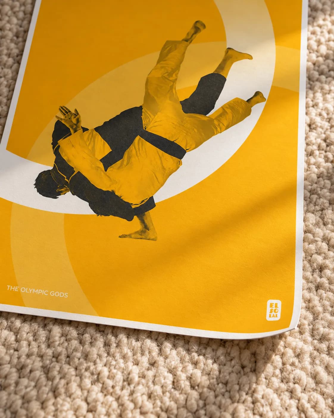 A corner of The Judoka lifting, the grain of the paper in raking light