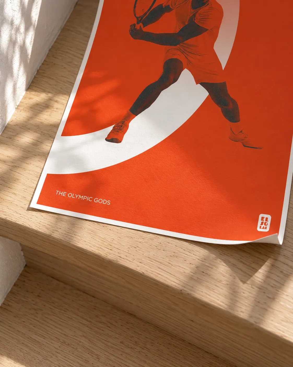A corner of The Tennisman lifting, the grain of the paper in raking light